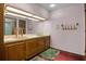Retro bathroom featuring dual sinks, wooden cabinetry, and a large mirror with vanity lighting at 6001 Sweet Gum Run, Bartow, FL 33830