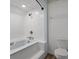 White tiled bathroom features a tub and shower combination and a toilet with a white vanity at 6001 Sweet Gum Run, Bartow, FL 33830