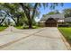 Spacious driveway with brick trim, a Tudor home, and lush landscaping at 6001 Sweet Gum Run, Bartow, FL 33830