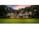 Charming Tudor-style home with a brick facade, lush green lawn, and a dark shingle roof at 6001 Sweet Gum Run, Bartow, FL 33830