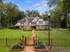 Charming Tudor-style home with a brick facade, black metal fence, and a stone pathway leading to the front door at 6001 Sweet Gum Run, Bartow, FL 33830