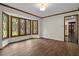 Bright living room features hardwood floors and a bay window, with an adjacent open doorway to another room at 6001 Sweet Gum Run, Bartow, FL 33830