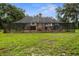 Wide shot of the backyard lawn with enclosed pool and screened enclosure at 6001 Sweet Gum Run, Bartow, FL 33830
