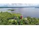 Aerial view of property with mature trees, home, and lake frontage at 6281 Halabrin Rd, Haines City, FL 33844