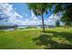 Expansive backyard with lush green grass and access to a serene lake and covered dock at 6281 Halabrin Rd, Haines City, FL 33844