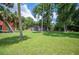 Green lawn surrounded by mature trees offering shade and privacy to a brick home at 6281 Halabrin Rd, Haines City, FL 33844