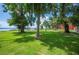 Exterior backyard view of brick home, large yard, and lake pier at 6281 Halabrin Rd, Haines City, FL 33844