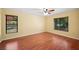 Bedroom with wood floors, a ceiling fan, and two windows offering natural light at 6281 Halabrin Rd, Haines City, FL 33844