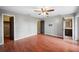 Bedroom with hardwood floors, ceiling fan, closet, and view into the bathroom at 6281 Halabrin Rd, Haines City, FL 33844