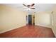 Bedroom with wood floors, ceiling fan, and access to the bathroom and closet at 6281 Halabrin Rd, Haines City, FL 33844