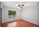 Bedroom with hardwood floors, a ceiling fan, and a window overlooking green foliage at 6281 Halabrin Rd, Haines City, FL 33844