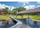 Lake view of covered dock on a waterway with seating area and view of neighboring property at 6281 Halabrin Rd, Haines City, FL 33844