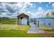 Wooden dock extending into the lake, featuring a covered boat house and scenic views at 6281 Halabrin Rd, Haines City, FL 33844