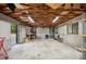 Spacious garage with exposed wood beams, concrete floor, and functional workspace at 6281 Halabrin Rd, Haines City, FL 33844