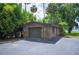 Exterior view of brick garage with asphalt driveway and mature trees at 6281 Halabrin Rd, Haines City, FL 33844