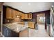 Kitchen featuring granite countertops, wood cabinets, stainless steel appliances, and tile floor at 6281 Halabrin Rd, Haines City, FL 33844