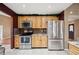 Kitchen featuring stainless steel refrigerator, oven, wooden cabinets, and granite countertops at 6281 Halabrin Rd, Haines City, FL 33844