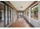 Enclosed sun porch with brick accents, tile flooring, and sliding glass door access to the outdoors at 6281 Halabrin Rd, Haines City, FL 33844