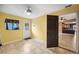 Room with tiled floor leading to the kitchen, with an exterior door and windows at 6281 Halabrin Rd, Haines City, FL 33844