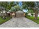 Beautiful home with a well-manicured lawn, large garage door, and brick driveway at 6342 Butternut Dr, Lakeland, FL 33813