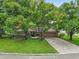 Charming single-story home with lush landscaping, large trees, and a brick driveway at 6342 Butternut Dr, Lakeland, FL 33813