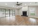 Spacious living room with fireplace, fan, hardwood floors, and sliding glass doors to the backyard at 6342 Butternut Dr, Lakeland, FL 33813