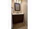 Cozy half-bathroom featuring a dark wood vanity, white countertop, and tiled floors at 6415 Torrington Cir, Lakeland, FL 33811