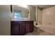 Bathroom with dark cabinets, sink, mirror, and shower-tub combination at 6415 Torrington Cir, Lakeland, FL 33811