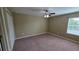 A cozy bedroom with neutral walls, carpet flooring, and a ceiling fan at 6415 Torrington Cir, Lakeland, FL 33811