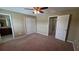 Spacious bedroom with a ceiling fan and carpet floors with view to the en-suite bathroom and closet at 6415 Torrington Cir, Lakeland, FL 33811