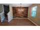 Dining room with hardwood style flooring, rustic feature wall and hanging chandelier at 6415 Torrington Cir, Lakeland, FL 33811