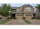 Townhome exterior with brick paver driveway and two-car garage at 6415 Torrington Cir, Lakeland, FL 33811