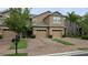 Inviting two-story townhome with a paver driveway, manicured landscaping, and an attached two-car garage at 6415 Torrington Cir, Lakeland, FL 33811