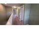 Carpeted hallway with neutral paint, white trim, and multiple doorways at 6415 Torrington Cir, Lakeland, FL 33811