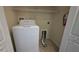 Small laundry room with white washing machine, tile floors and storage shelf at 6415 Torrington Cir, Lakeland, FL 33811
