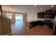Open-concept living space with a kitchen island, dark cabinets, wood floors, and sliding doors to a screened patio at 6415 Torrington Cir, Lakeland, FL 33811