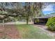Backyard view featuring mature trees, expansive lawn, and exterior elements of the property at 6819 Broken Arrow S Trl, Lakeland, FL 33813