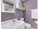 Cozy bathroom featuring lilac walls, a white vanity, and decorative accents at 6819 Broken Arrow S Trl, Lakeland, FL 33813
