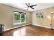 Bedroom featuring hardwood floors, a ceiling fan, and a large window with natural lighting at 6819 Broken Arrow S Trl, Lakeland, FL 33813