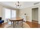 Bright dining room features hardwood floors, modern light fixture, and updated trim and molding at 6819 Broken Arrow S Trl, Lakeland, FL 33813