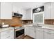 Modern kitchen features white cabinetry, stainless appliances, and stylish backsplash at 6819 Broken Arrow S Trl, Lakeland, FL 33813