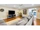 Open-concept living room features hardwood floors, entertainment center, and comfortable gray seating at 6819 Broken Arrow S Trl, Lakeland, FL 33813