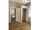 Bedroom features wood-look flooring, open closet with shelving, and access to another room at 8159 Woodvine Cir, Lakeland, FL 33810