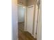 View of hallway with closet and doorway to room with wood-look flooring and ceiling fan at 8159 Woodvine Cir, Lakeland, FL 33810