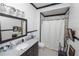 Classic bathroom features black-and-white tile floors, a modern vanity, and shower with white curtain at 817 College Ave, Lakeland, FL 33801