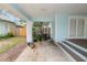Covered porch with light blue support columns, concrete flooring, and steps to the side yard at 817 College Ave, Lakeland, FL 33801