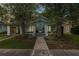 Charming light-blue home with mature trees, a walkway, and a well-manicured lawn at 817 College Ave, Lakeland, FL 33801