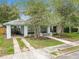 Charming light blue home with a covered porch, mature trees, and a well-manicured front yard at 817 College Ave, Lakeland, FL 33801