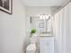 A white toilet and a vanity with a granite countertop in a bathroom, accented by a potted plant at 818 Woodward St, Lakeland, FL 33803