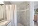 Bathroom with vanity and tub/shower combo showcasing gray tiled walls and striped shower curtain at 818 Woodward St, Lakeland, FL 33803